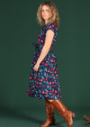 Model wears long dress with pockets and buttons