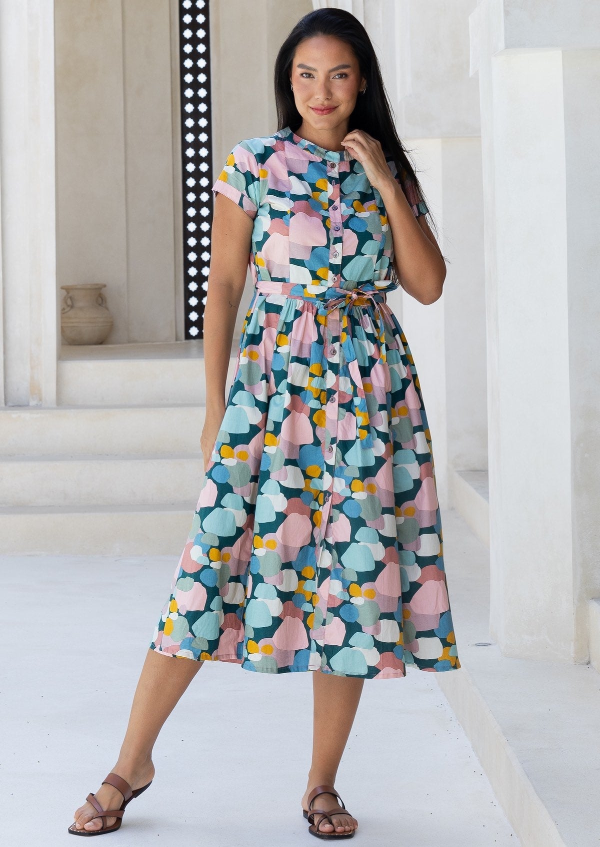 Woman standing in cotton 50's style button through dress in pastel colours