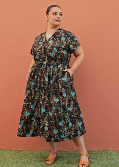 Plus size model wearing retro style cotton dress in black and teal with pockets