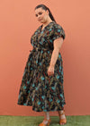 Plus size model wearing Vivien dress in black and teal with pockets