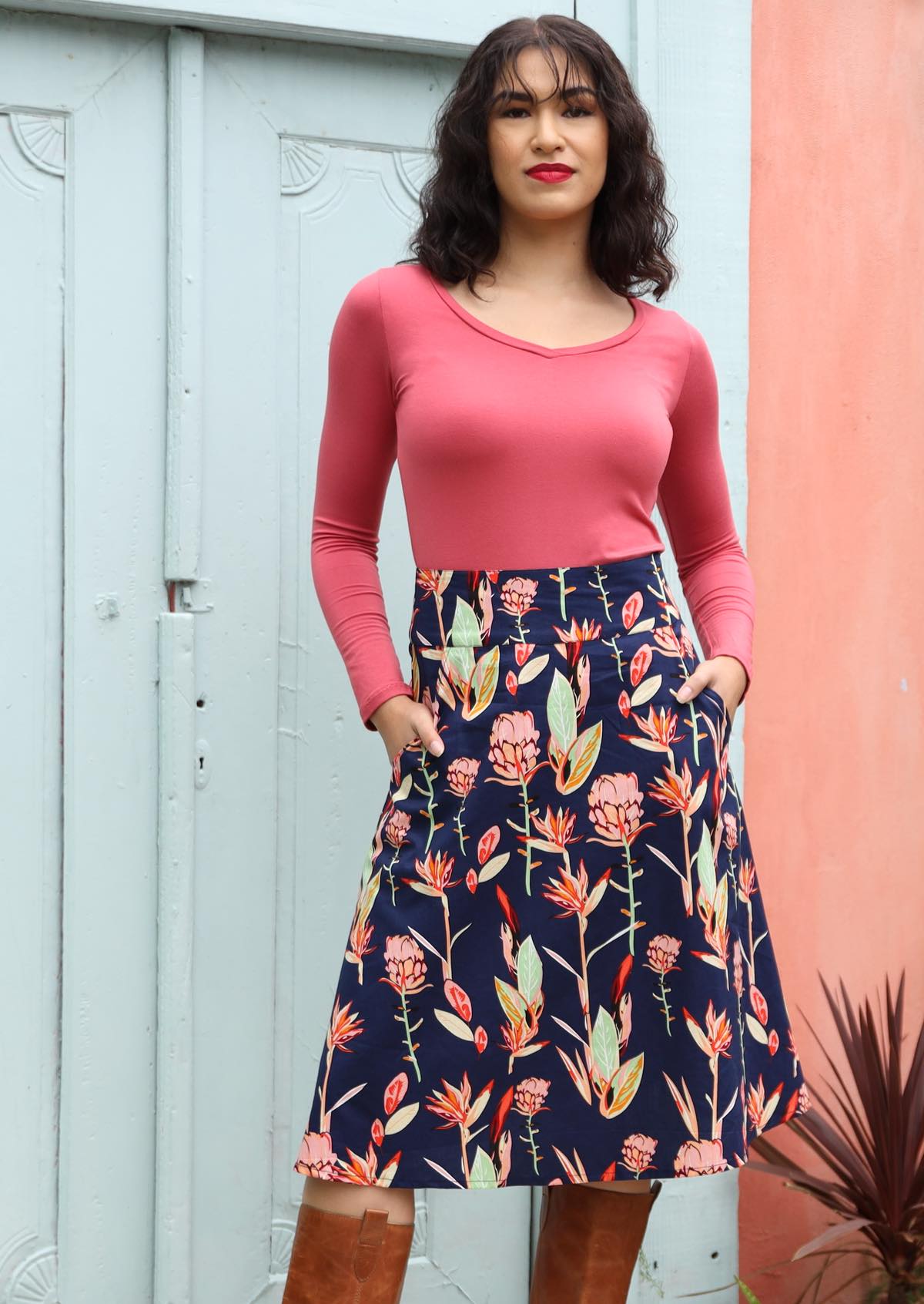 Woman wears A-line cotton skirt with pockets and long sleeve stretch pink top.