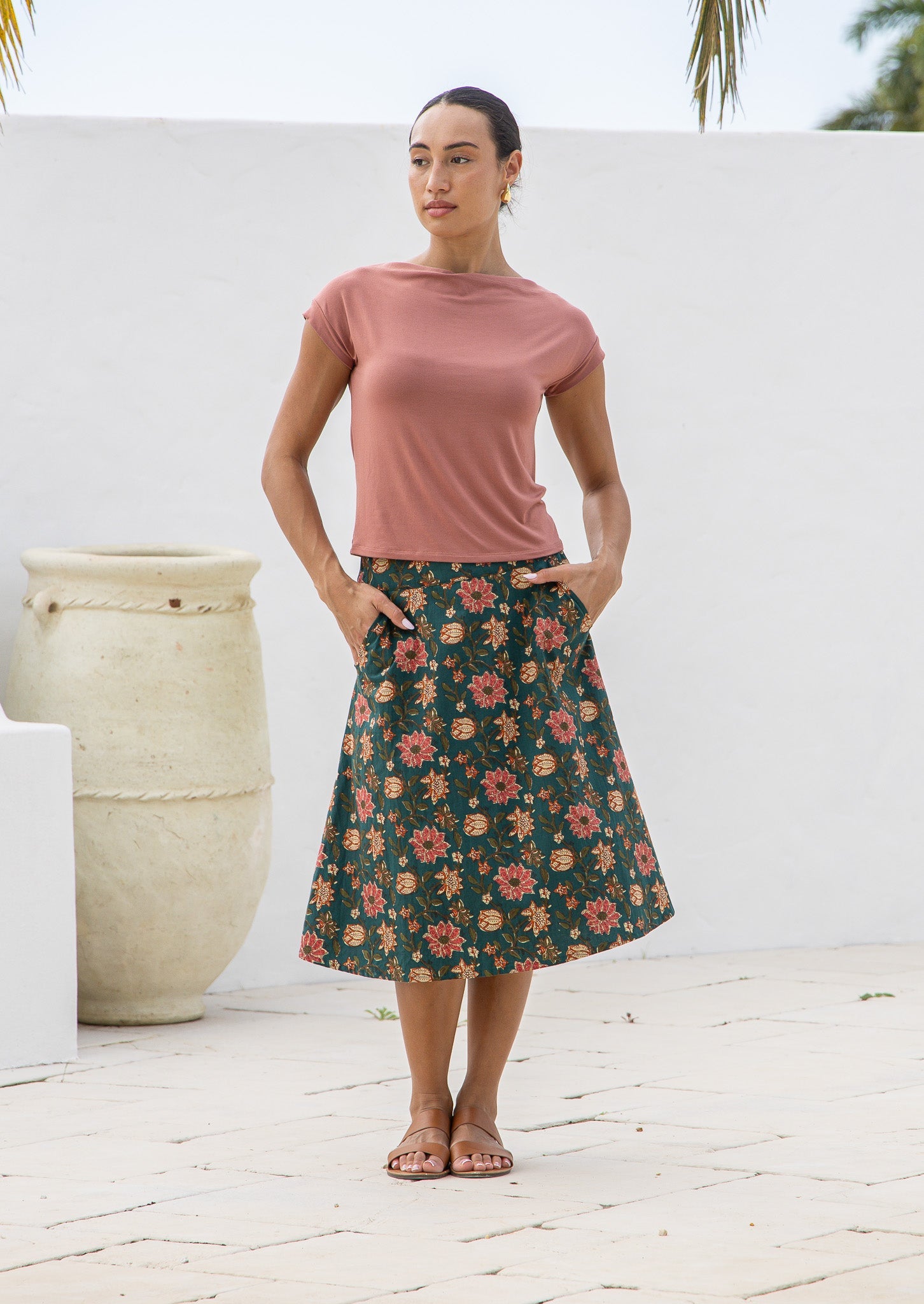 Model wears a beautiful deep green floral   skirt with pockets, wide waistband and side zipper.