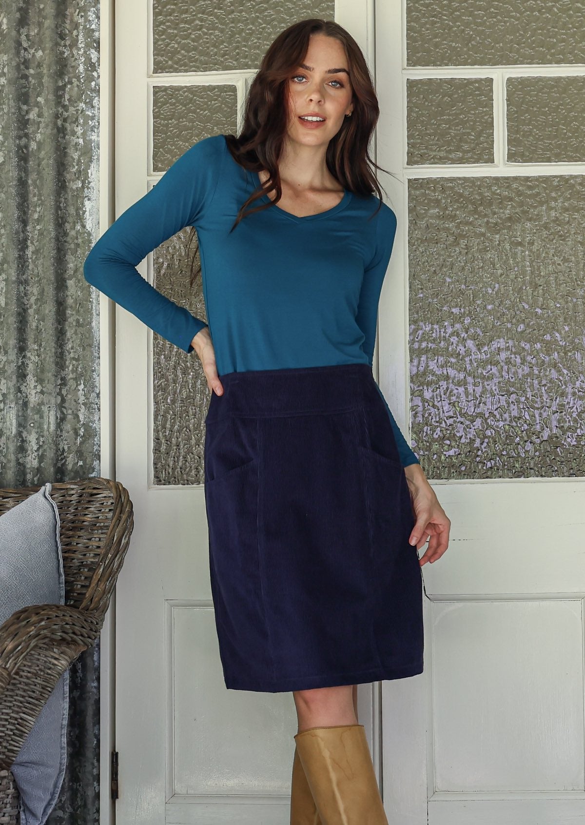woman wearing a cotton corduroy skirt in  and basic top with knee-high boots