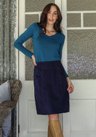 woman wearing a cotton corduroy skirt in  and basic top with knee-high boots