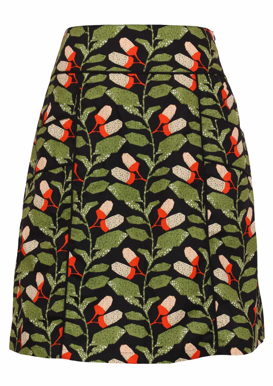 Model wears Aalia Skirt Oak green, orange and white speckled botanical print on black base 100% cotton, knee length A-line skirt with side zip and pockets | Karma East