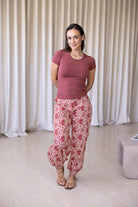 Woman wearing floral cotton wide leg pants with buttoned ankle paired with pink basic top