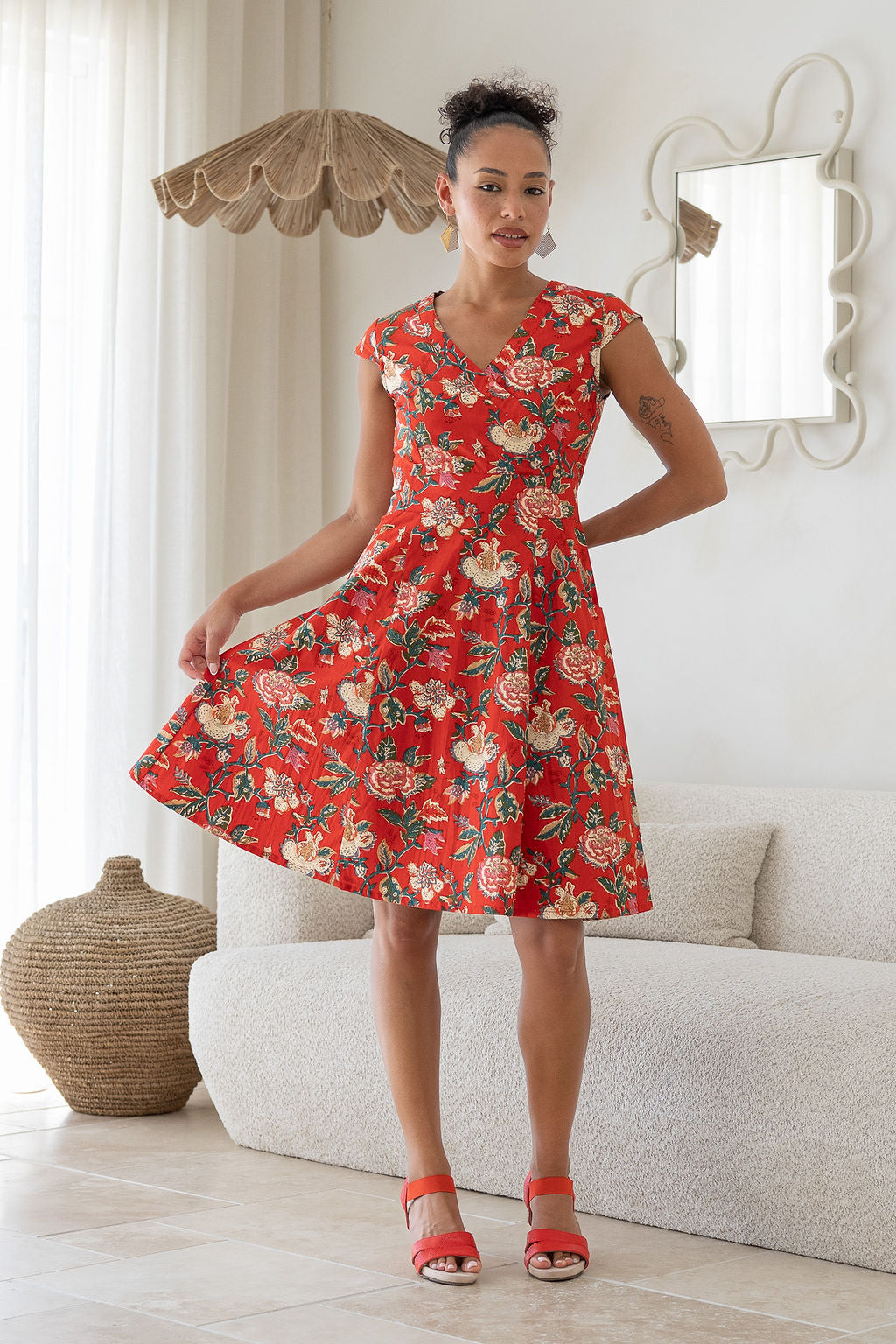 Model wears a 100% cotton dress featuring cap sleeves, pockets and a generous A-line skirt.