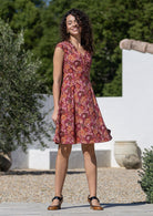 Woman wearing a cotton above knee dress with cap sleeves, pockets and generous skirt