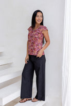 Model posing in a floral print tailored cotton top with cap sleeves, round neckline and length sitting at the hip 