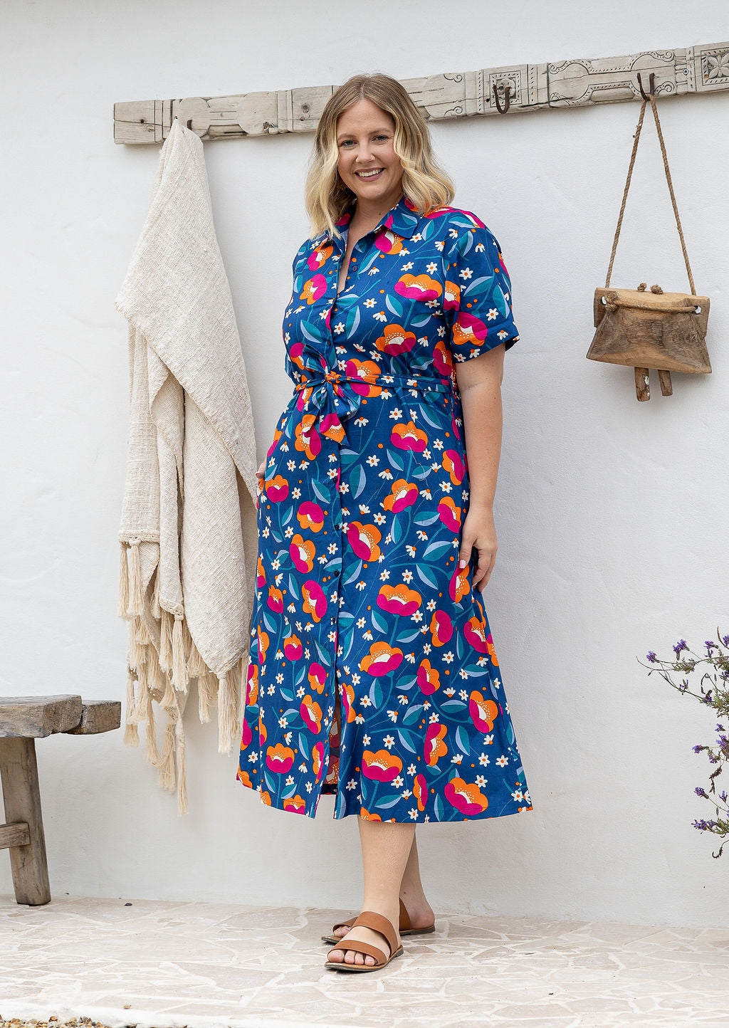 Model standing in a floral printed shirt dress with detachable fabric belt and short sleeves 