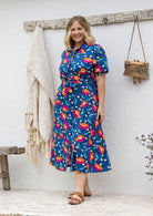 Model standing in a floral printed shirt dress with detachable fabric belt and short sleeves 