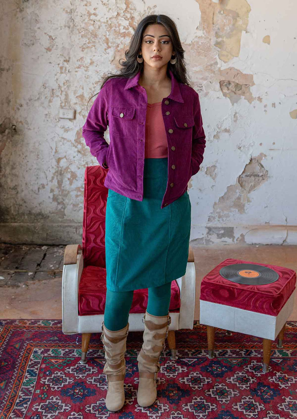 Woman standing wearing 100% cotton corduroy jacket with breast and front pockets, brass buttons, and collar