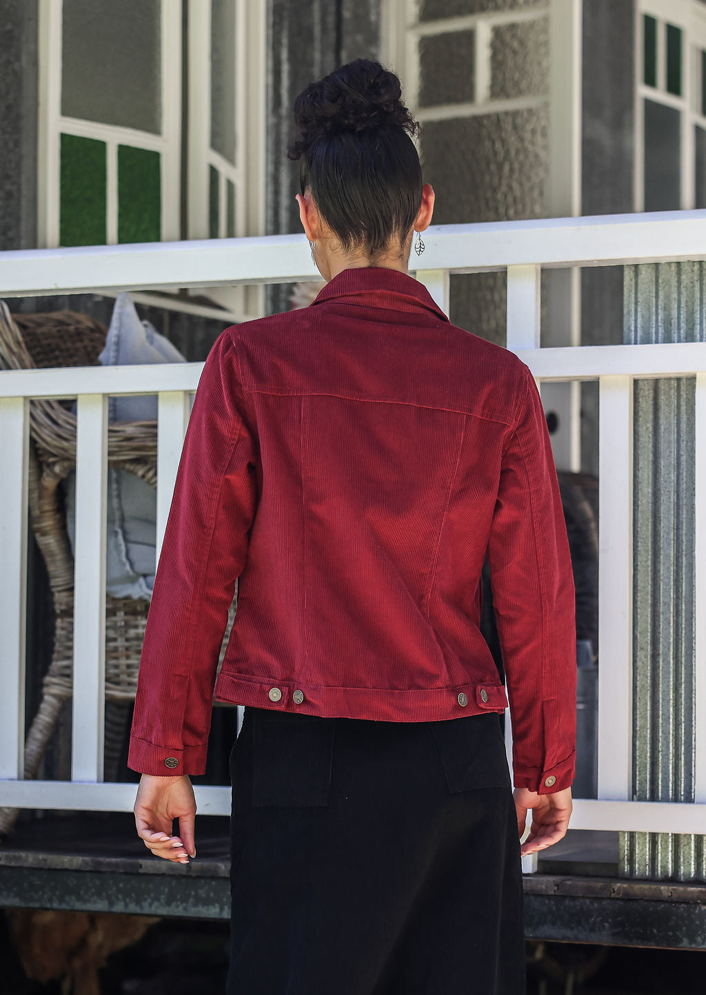 woman standing backwards wearing a  deep, luxurious, and intense red-purple hue cotton corduroy jacket 