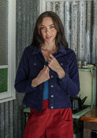 Woman wearing a cotton corduroy jacket and corduroy pants standing in a kitchen.