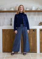 Woman wearing a deep, rich, and slightly muted navy blue long sleeve jacket with front and breast pockets