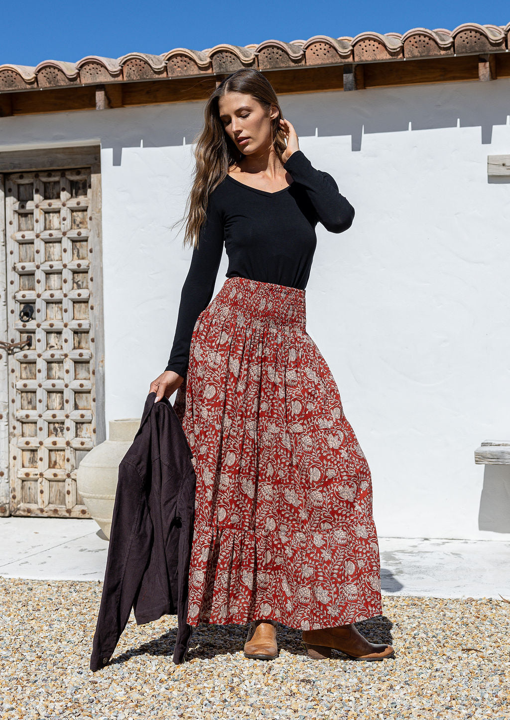 Model is wearing 100% cotton tiered maxi skirt in red based floral print with wide elasticated waistband.