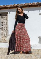 Model is wearing 100% cotton tiered maxi skirt in red based floral print with wide elasticated waistband.