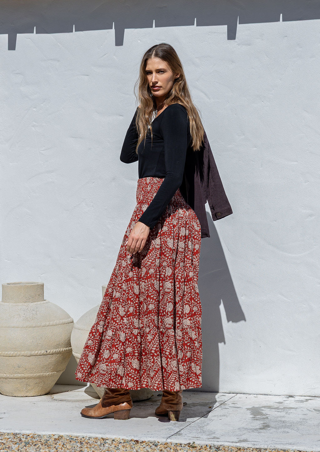 Model is wearing 100% cotton tiered maxi skirt in red based floral print.