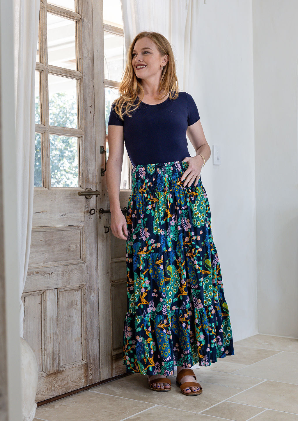 woman wearing a simple navy top and 100% cotton maxi skirt in navy based colourful floral print. 