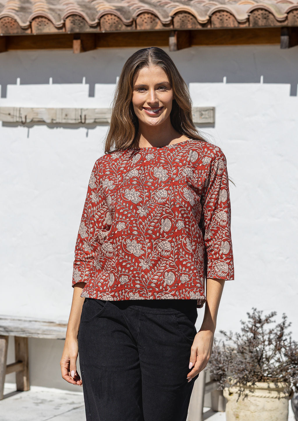 Model wears relaxed fit cotton top with 3/4 sleeves and round neckline in red based floral print.