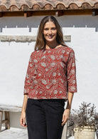Model wears relaxed fit cotton top with 3/4 sleeves and round neckline in red based floral print.