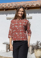 Model wears loose fit cotton top in red based floral print with black pants