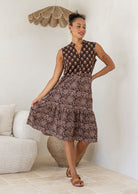 Woman wearing a brown Indian Cotton patterned dress in a living room setting