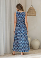 Woman facing away wearing a sleeveless cotton maxi dress in a navy based floral print