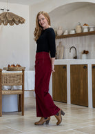 Woman stands sideways wearing a cotton corduroy wide leg pants with black basic top.