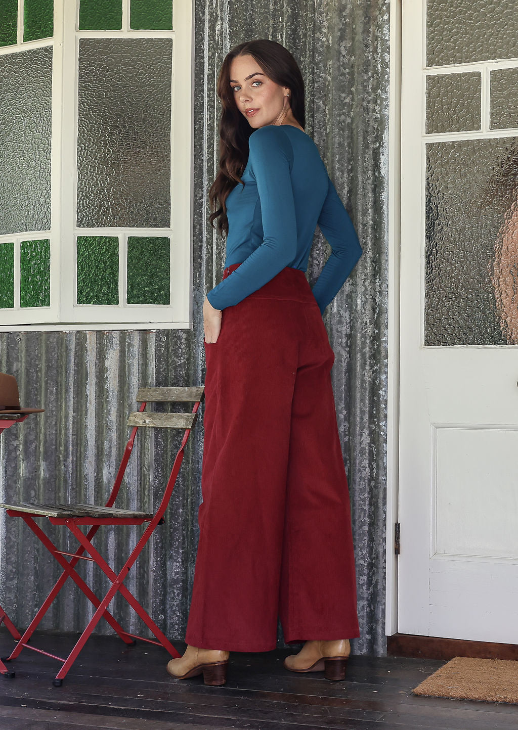 woman standing sideways wearing a cotton corduroy pants and a basic top with hands in pockets