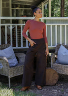 Woman in pink top and brown cotton corduroy wide leg pants with one hand in pockets