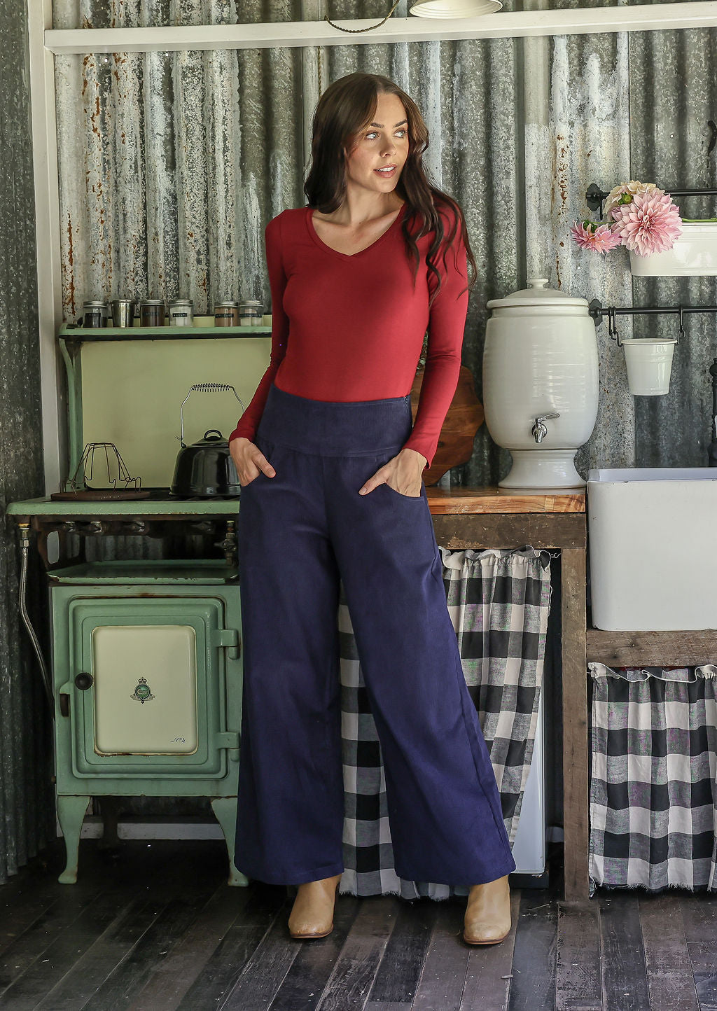 Woman in red top and blue cotton corduroy wide leg pants with hands in pockets