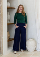 Woman wearing a corduroy wide leg pants in deep navy blue with both hand in pockets 