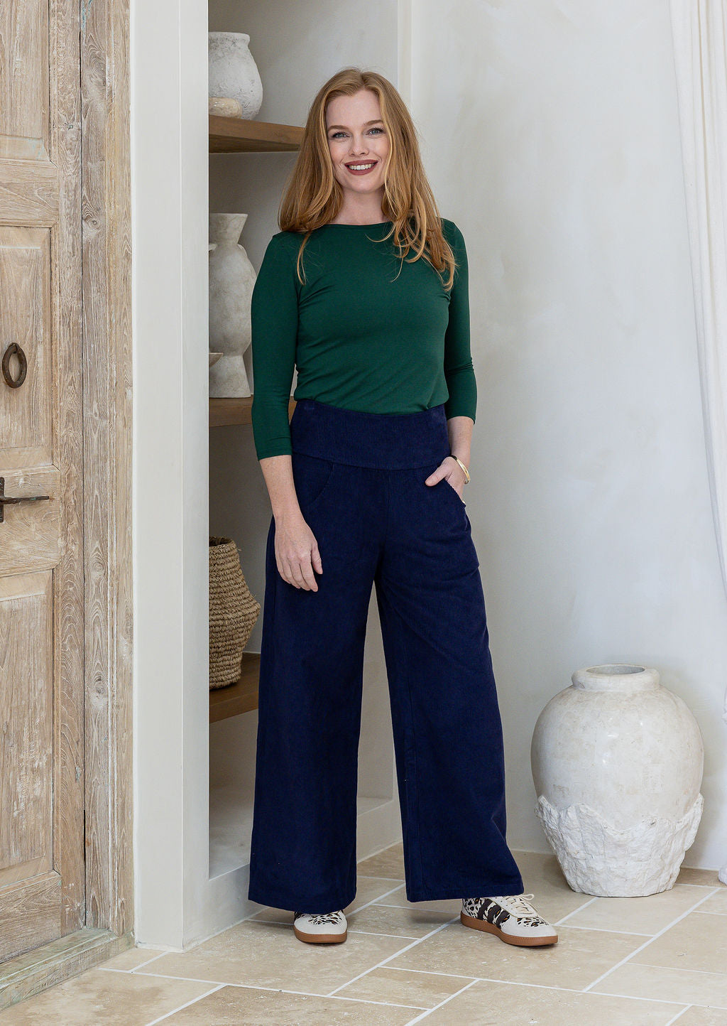 Woman in green basic top and blue cotton corduroy wide leg pants with wide waistband and pockets