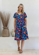 Model wearing a cotton V-neck short sleeve dress with empire waistline and  pocket.