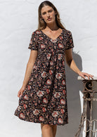 Model poses in a cotton V-neck short sleeve dress with empire waistline and  pocket.