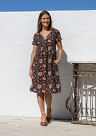 Model wearing a cotton V-neck short sleeve dress with empire waistline and  pocket.