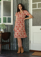 Model wearing a cotton knee length dress with empire waist, short sleeves and pockets.
