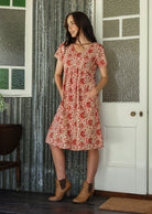 Model wearing a cotton V-neck short sleeve dress with both hand in pockets. 