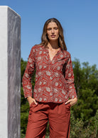 Woman wearing a 100% cotton top in red based floral print with V neckline