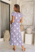 Model wearing navy floral rayon wrap maxi sundress in 100% rayon