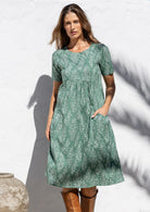 Woman posing in cotton over the knee length relaxed fit sun dress with short sleeves, with her hand in a pocket