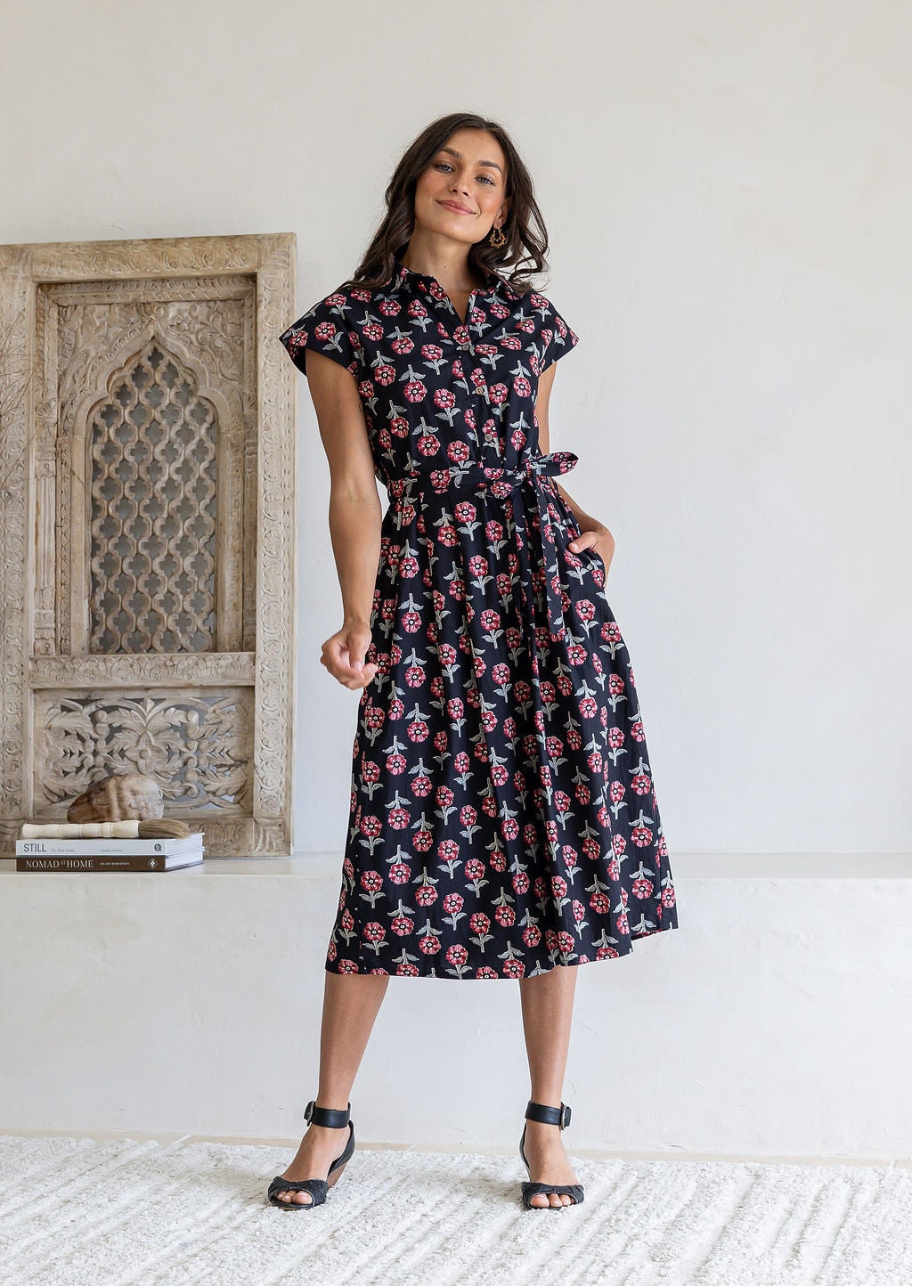Woman wearing Black floral midi shirt dress with cap sleeves and tie waist. 