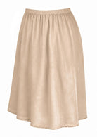 Nude toned slight A-line cotton slip skirt with elasticated waist and picot trim on hem, side view