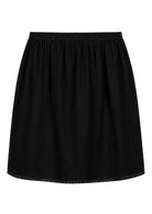 Black slight A-line cotton slip skirt with elasticated waist and picot trim on hem, back view