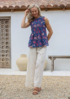 Woman wearing a floral cotton top and  100% cotton wide leg pant in natural white with drawstring waist tie, pockets and elastic waist
