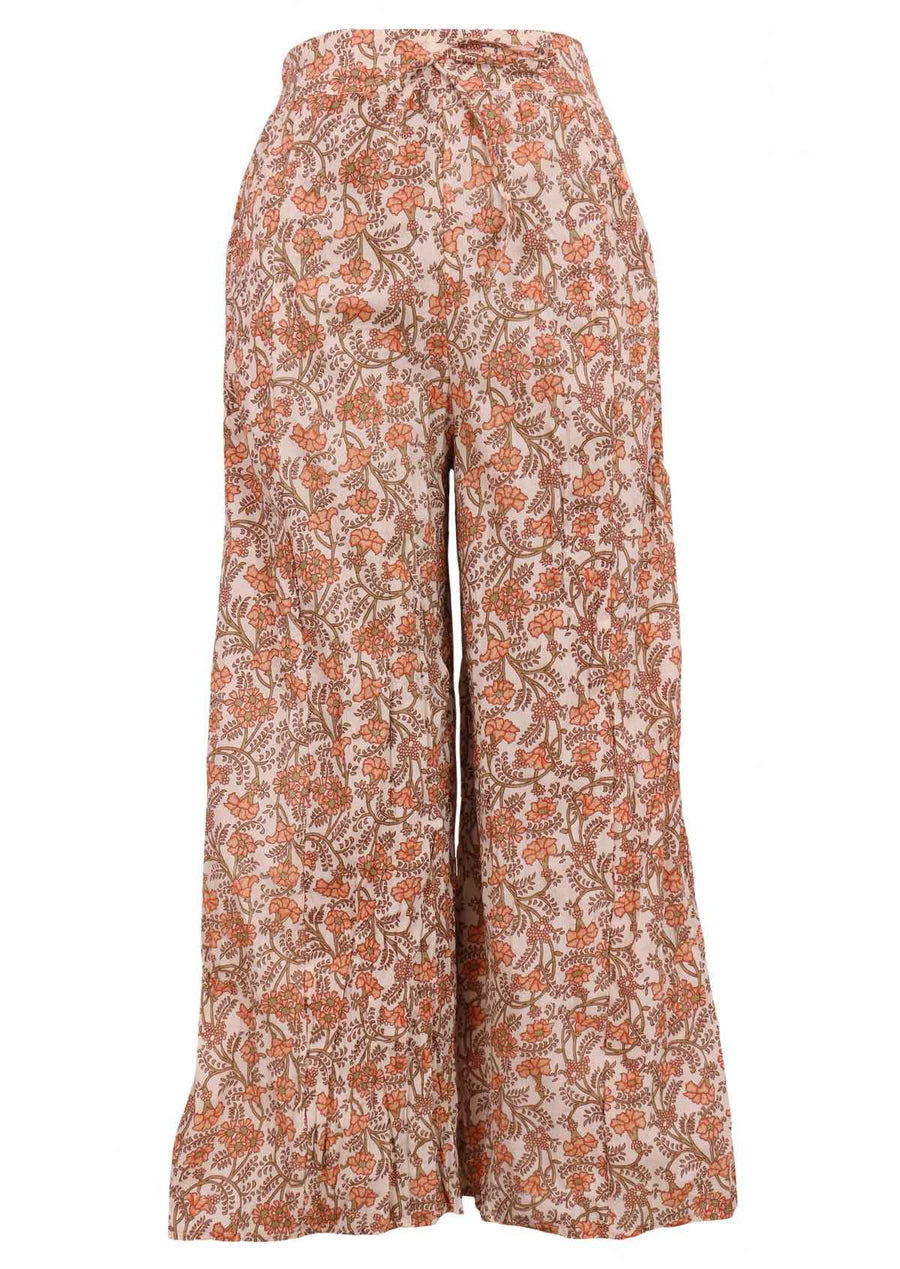 Model wears peachy floral print on cream base cotton wide leg lightweight cotton pants with elastic at back of waistband and drawstring and pockets | Karma East Australia