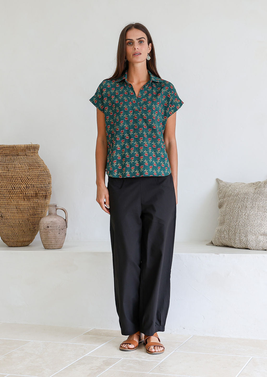 Woman poses in relaxed fit cotton short sleeve top with rolled cuffs sleeves, collar and V neckline.