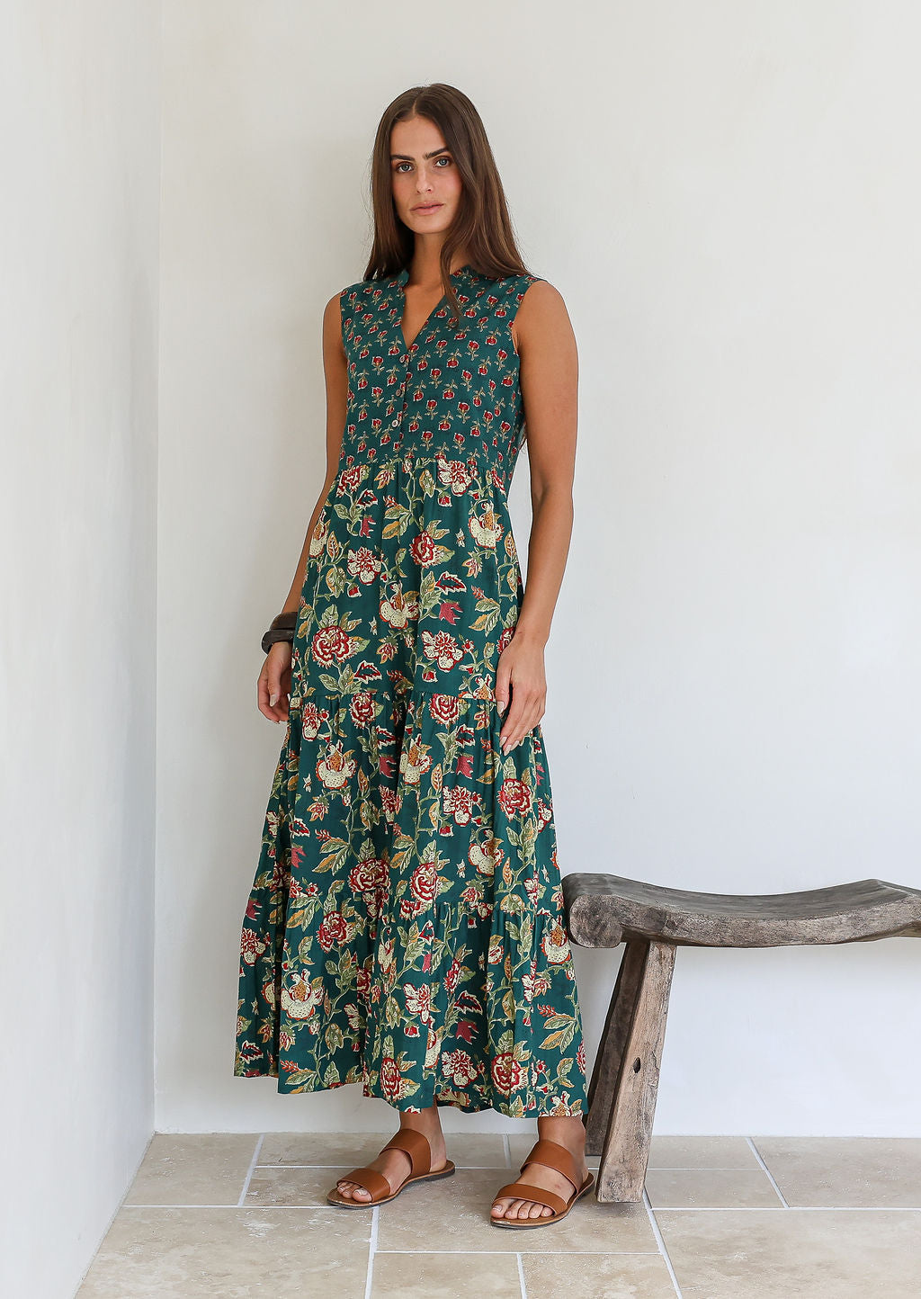 Model wearing a cotton three tiered maxi dress with  3/4 sleeves and buttoned bodice in combination of two green based floral prints.