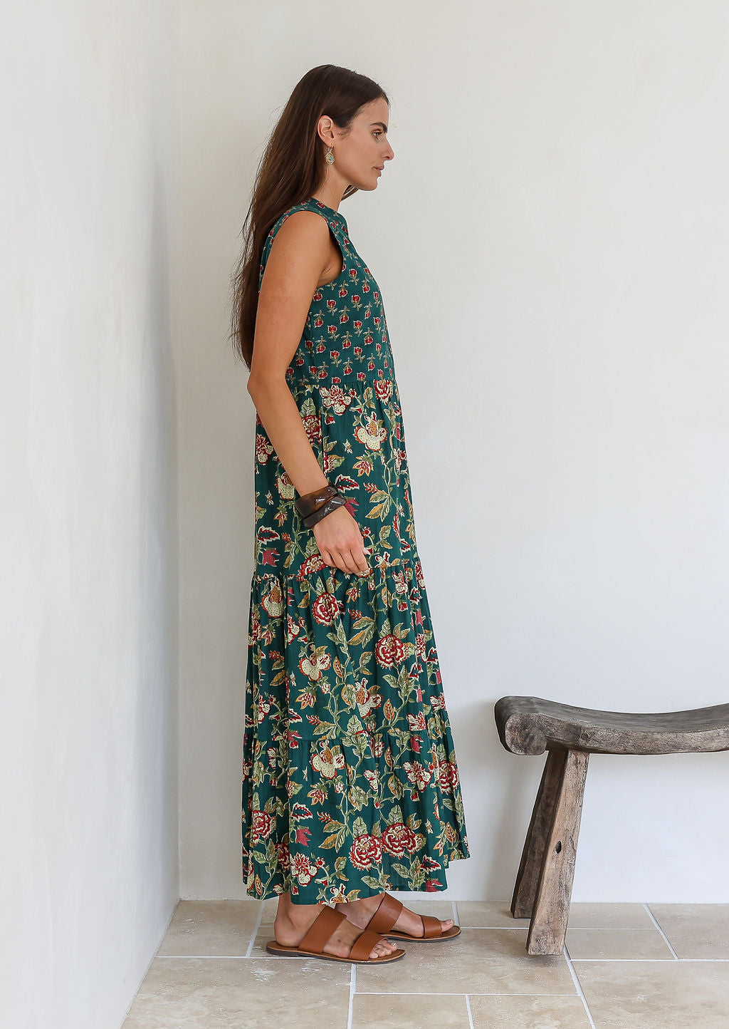 Model stands sideways wearing a 100% cotton 3 tiered maxi dress with flowy skirt, 3/4 sleeves, buttoned bodice and pockets.